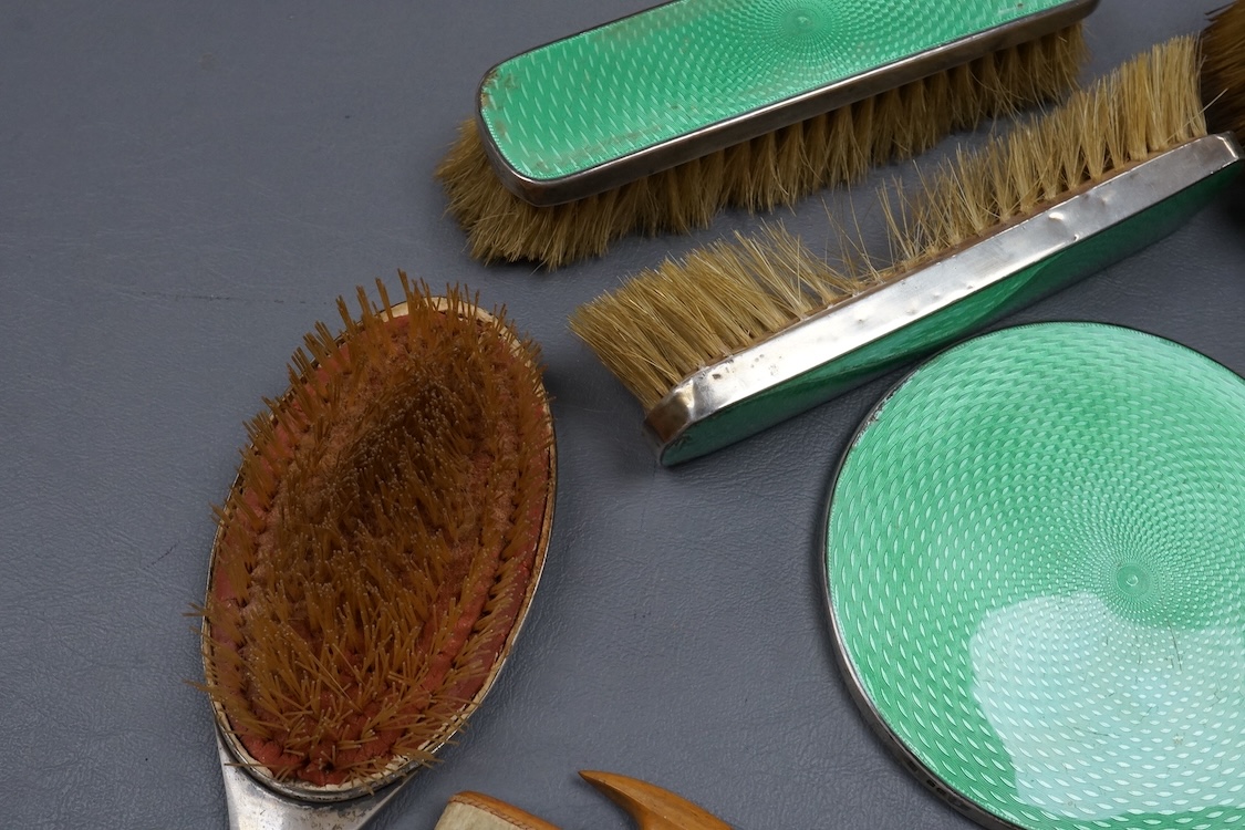 A George V silver and green guilloche enamel mounted five piece mirror and brush set, by William Neale & Son Ltd, Birmingham, 1931 (a.f.).